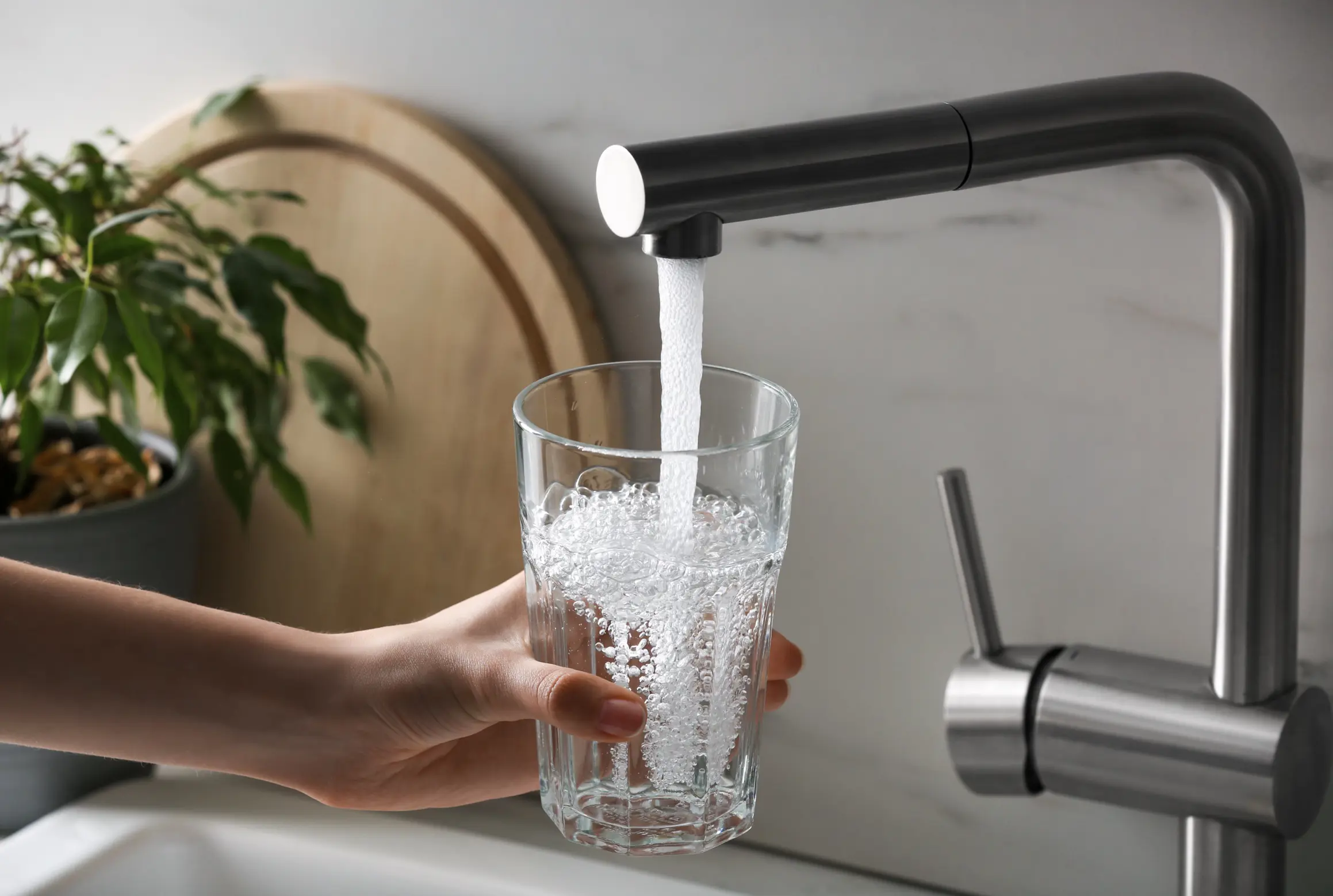 A person filling a cup with tapwater