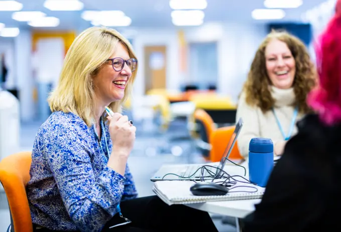 A group of office workers smiling and laughing