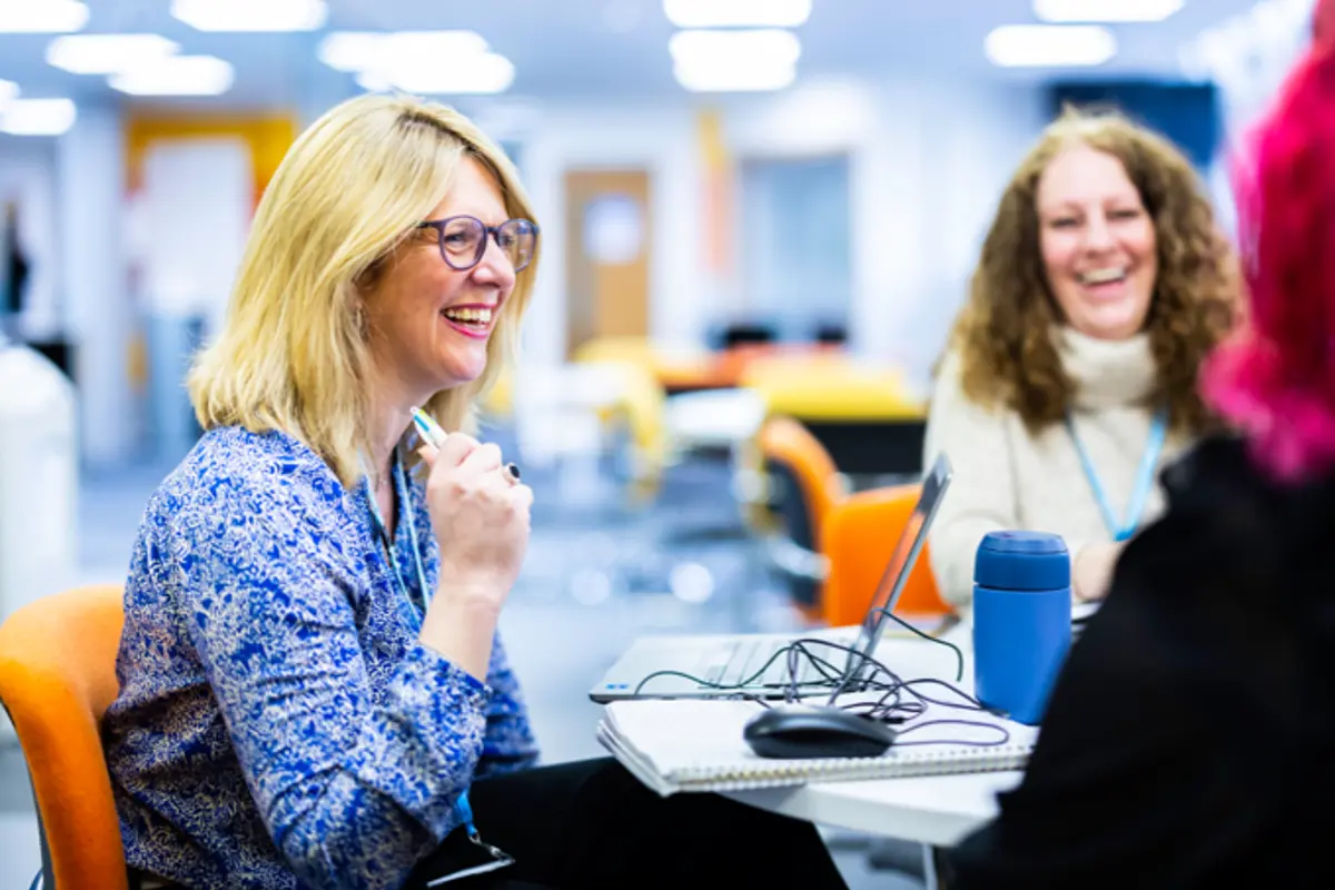 A group of office workers smiling and laughing